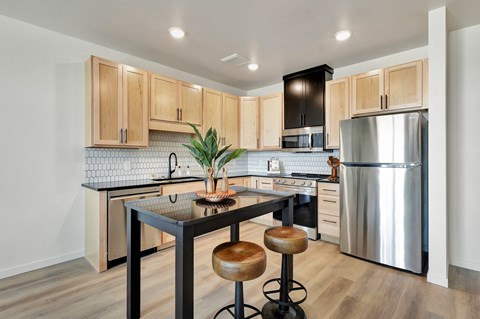 A kitchen with a table and chairs in the middle of it.