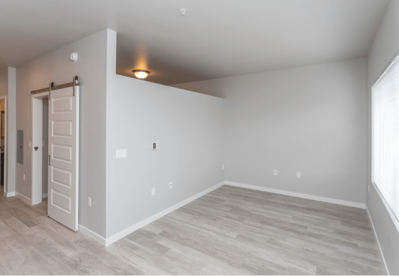 the room is empty and has a white wall and wood flooring