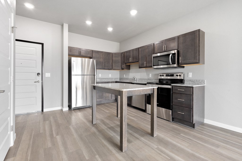 a kitchen with stainless steel appliances and a island in the middle
