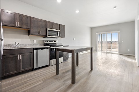 a kitchen and living room with wooden floors and wooden cabinets