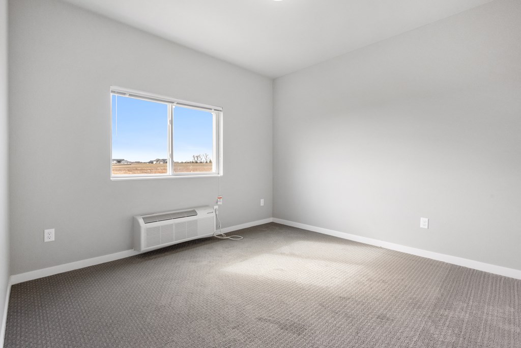 an empty room with carpet and a window