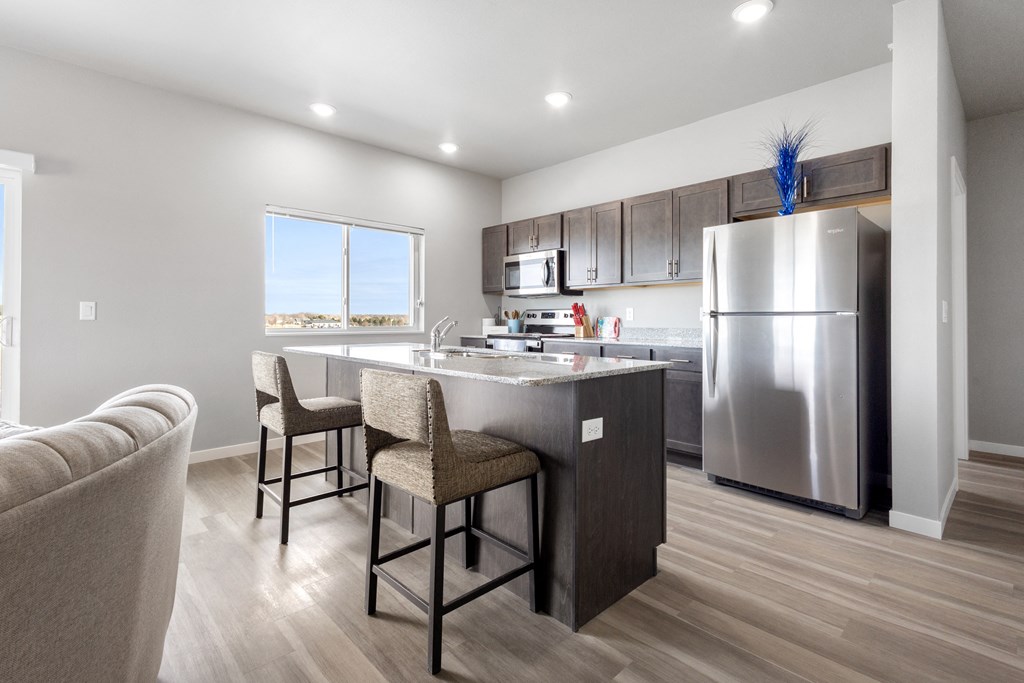 a kitchen with stainless steel appliances and a large island with chairs