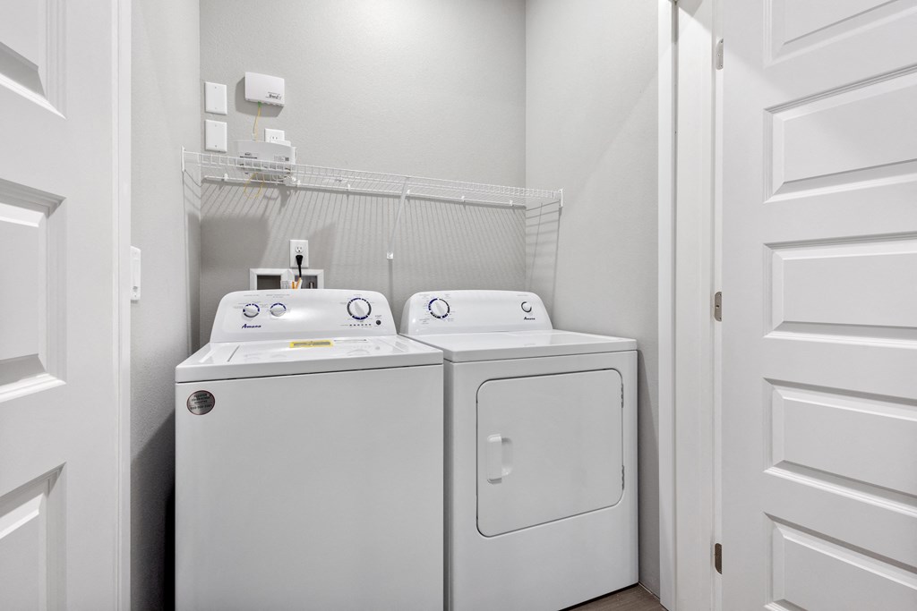 a washer and dryer in a laundry room with a white door