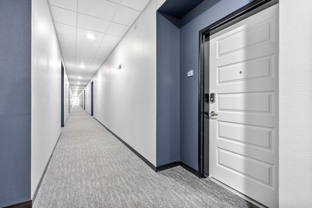 a hallway with blue walls and a white door