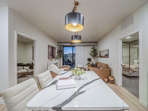 A modern dining room with a white table and chairs.