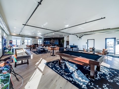 A room with a pool table and a bar.