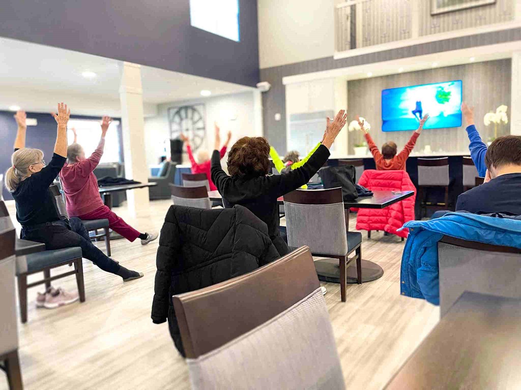 a group of people sitting in a room with their hands in the air