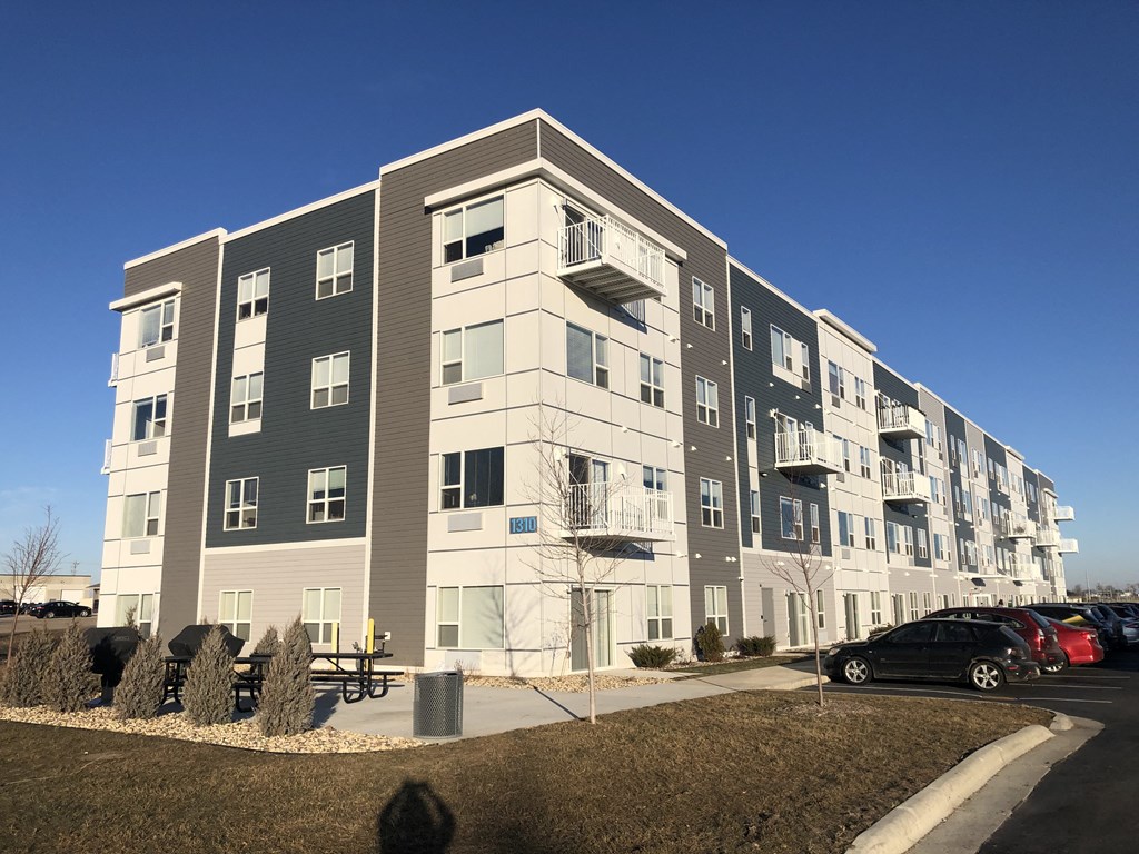 an apartment building with cars parked in front of it