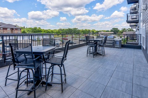 A patio with a table and chairs overlooking a parking lot.