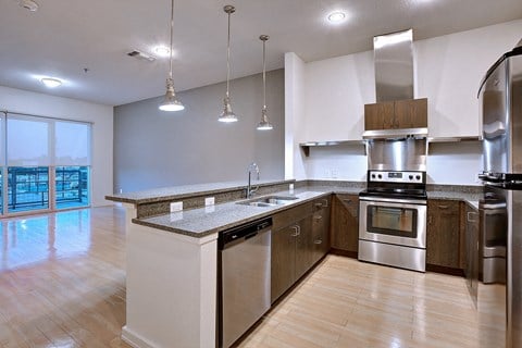 Beautiful apartment kitchen with stainless steel appliances and granite counters and bar