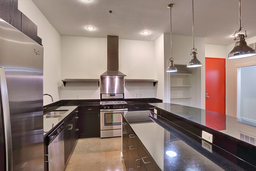 Apartment kitchen with industrial feel vent hood at The Mosaic on Broadway, San Antonio, TX, 78215