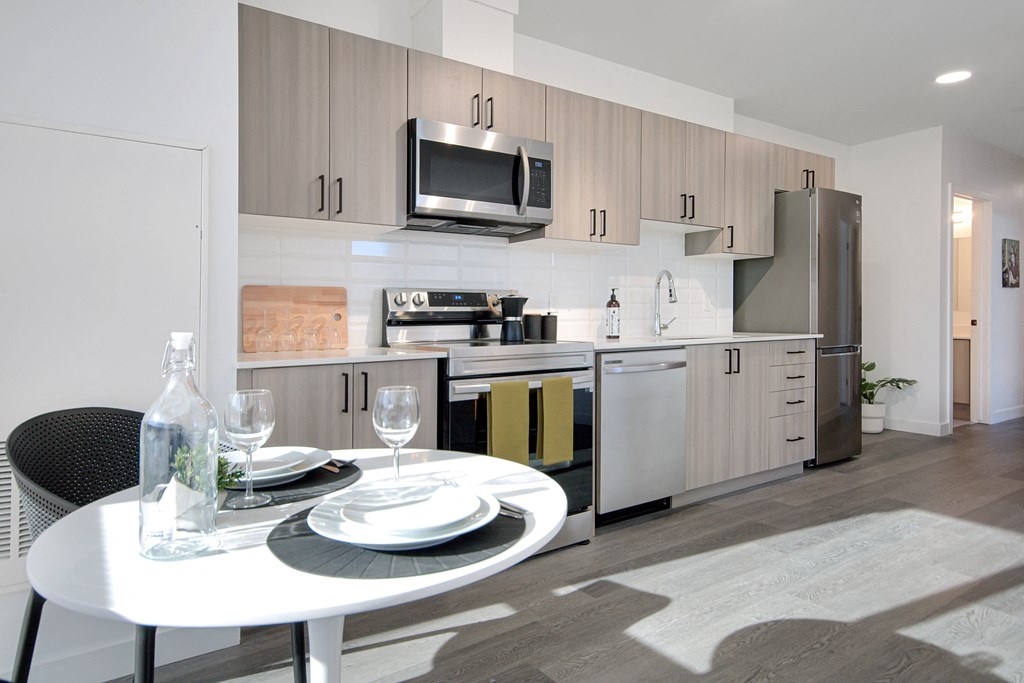 a kitchen and dining room with stainless steel appliances and a table