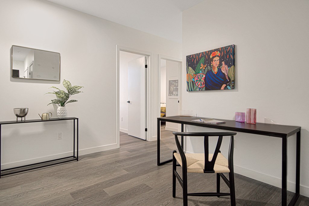 a room with a desk and a chair and a painting on the wall