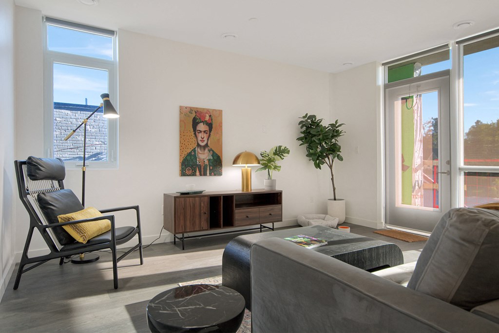 a living room with a couch and chairs and a large window