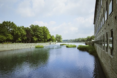 A river flows through a city with a building on the right.