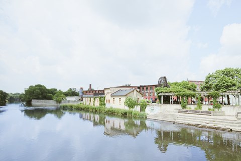 A serene riverside scene with a building and a dock.