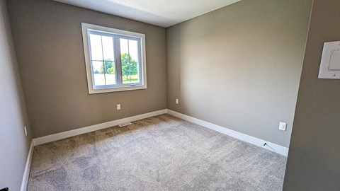 an empty room with carpet and a window