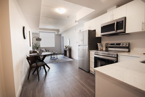 A kitchen with a refrigerator, oven, and microwave.