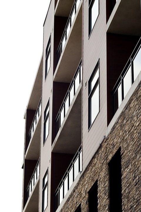 A tall building with a balcony on each floor.