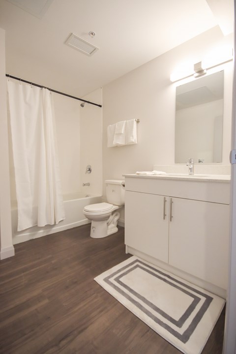 A white bathroom with a toilet, sink, and shower.
