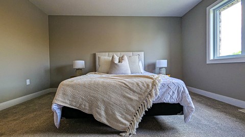 a bedroom with a bed and two windows