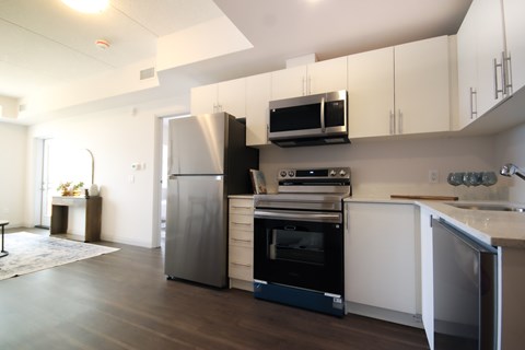 A modern kitchen with a refrigerator, oven, and microwave.