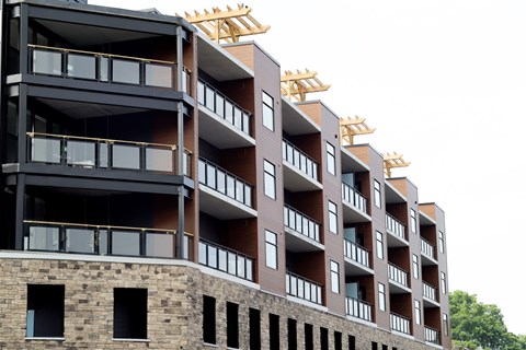 A multi-story building with balconies and windows under construction.