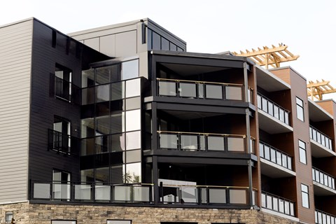 A modern multi-story building with black and brown balconies.
