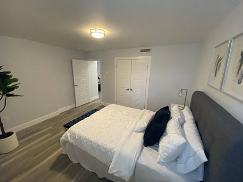 a bedroom with a large bed and a door to a bathroom