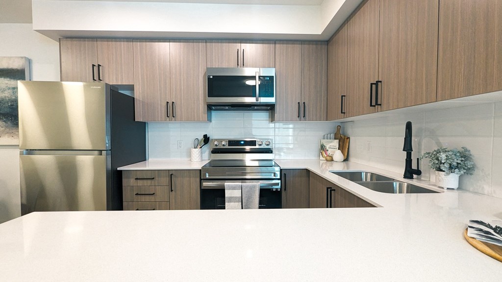 a modern kitchen with white counter tops and wooden cabinets