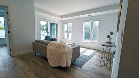 a living room with a couch and a chair in front of a window