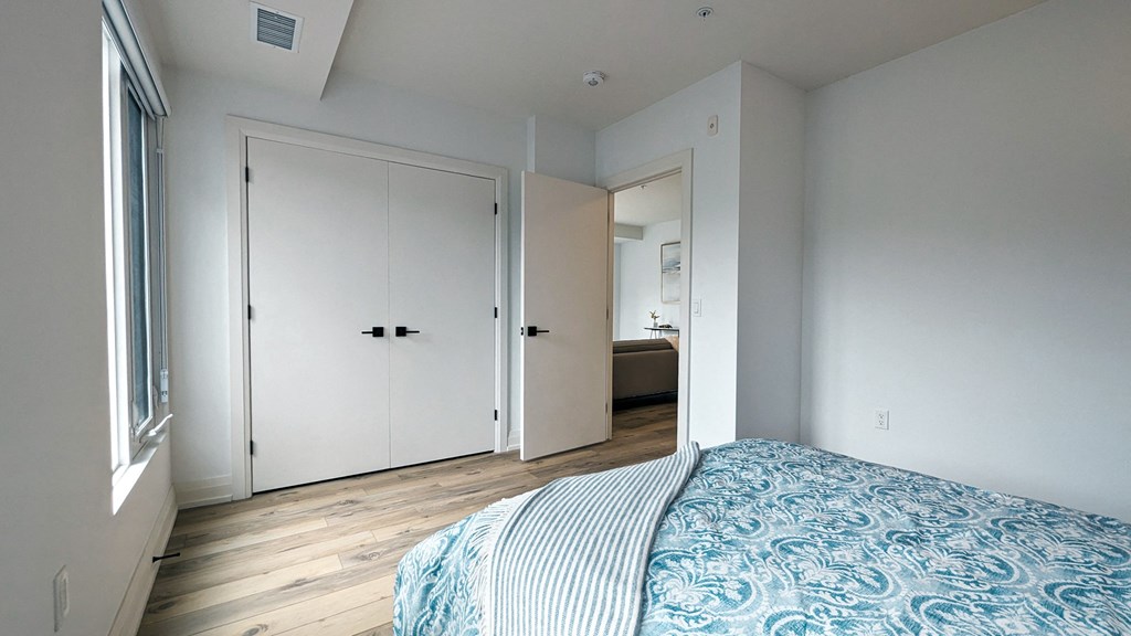 a bedroom with a bed and a closet and a bathroom