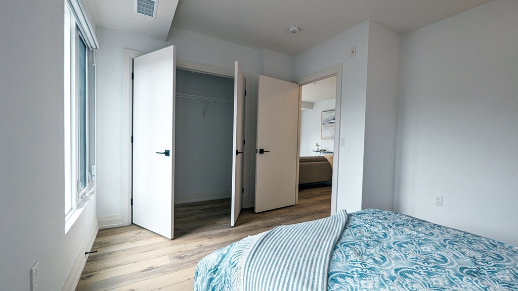 a bedroom with a bed and a closet and a bathroom