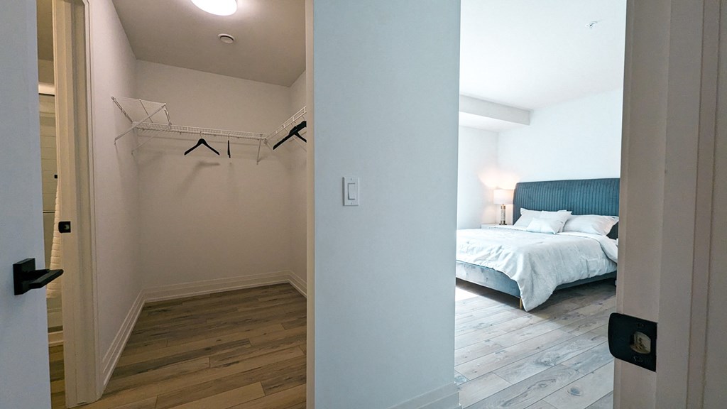 a bedroom with a bed and a closet      and a mirror