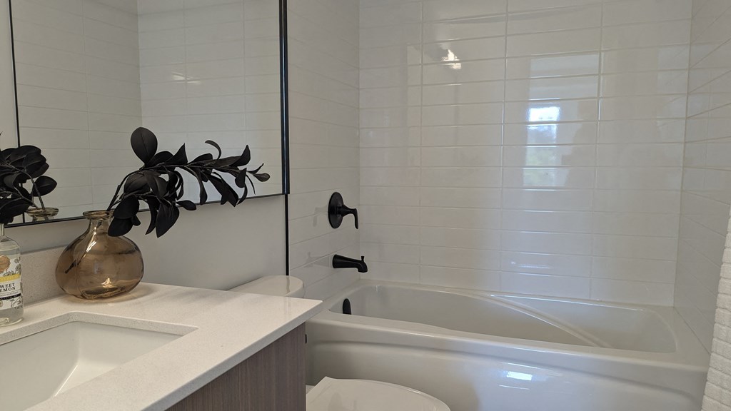 a white bathroom with a tub and a sink