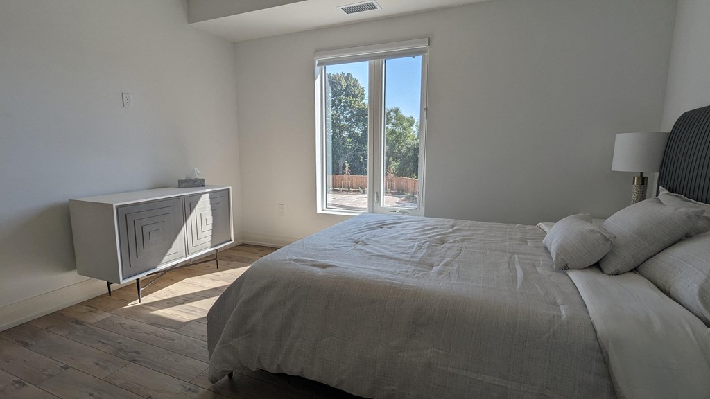 a bedroom with a bed and a large window