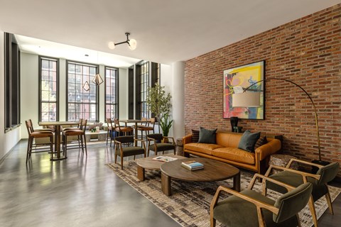 A living room with a brown couch and a large painting on the wall.