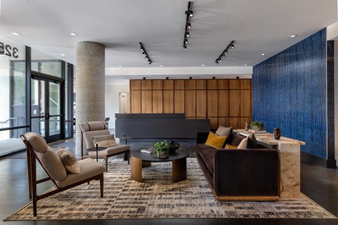 A modern living room with a dark brown couch, a wooden coffee table, and a large window.