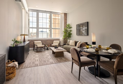 A modern living room with a dining table set for two.