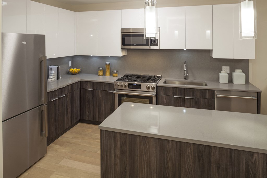a kitchen with stainless steel appliances and white counter tops