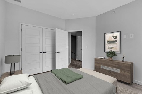 A bedroom with a bed, nightstand, and a painting on the wall.