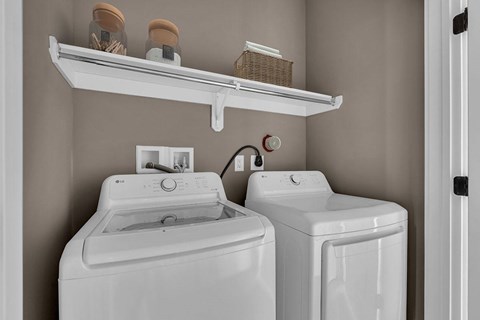 A white washing machine and dryer in a laundry room.