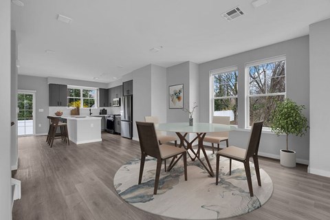 A modern kitchen with a dining table and chairs.