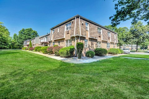 Exterior photo of Beekman Gardens in Hillsborough, showing a typical apartment building. Lush green landscaping and trees can be seen around the property.