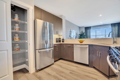 A modern kitchen with a stainless steel refrigerator and wooden cabinets.