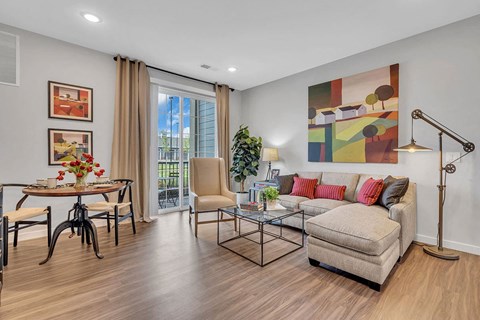 A living room with a couch, chairs, and a painting on the wall.