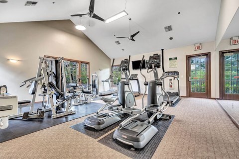 Interior photo of the Pike Run Community Clubhouse, showing the indoor gym with various pieces of cardio and strength training equipment.