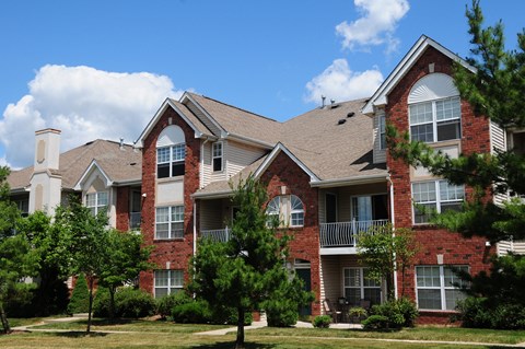Pike Run Village Exterior photo showing several balconies. Several bushes and trees highlight the landscape.