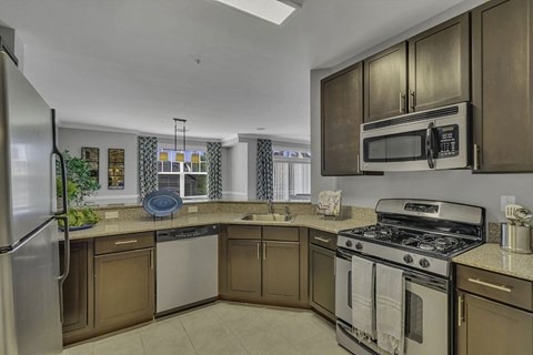 A kitchen with brown cabinets and a stainless steel refrigerator.