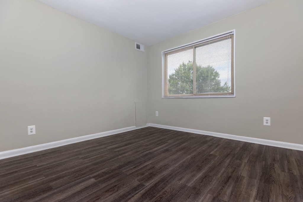 a bedroom with hardwood floors and a large window at Highland Ridge, Capitol Heights, 20743